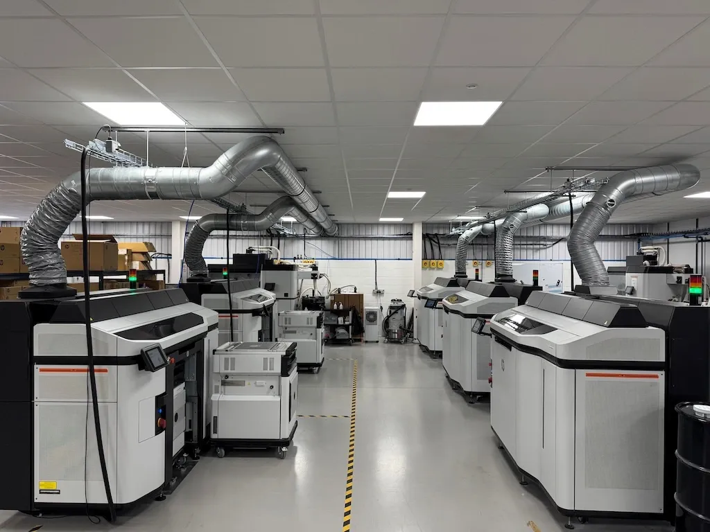 Multiple 3D printers on the factory floor.