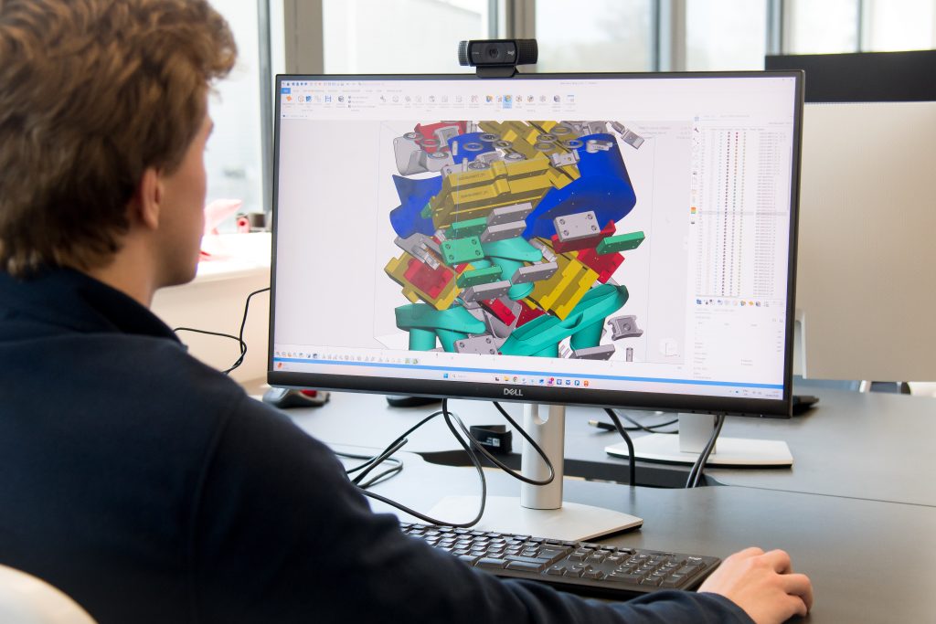 An AMufacture engineer reviewing a colour-coded build layout on screen