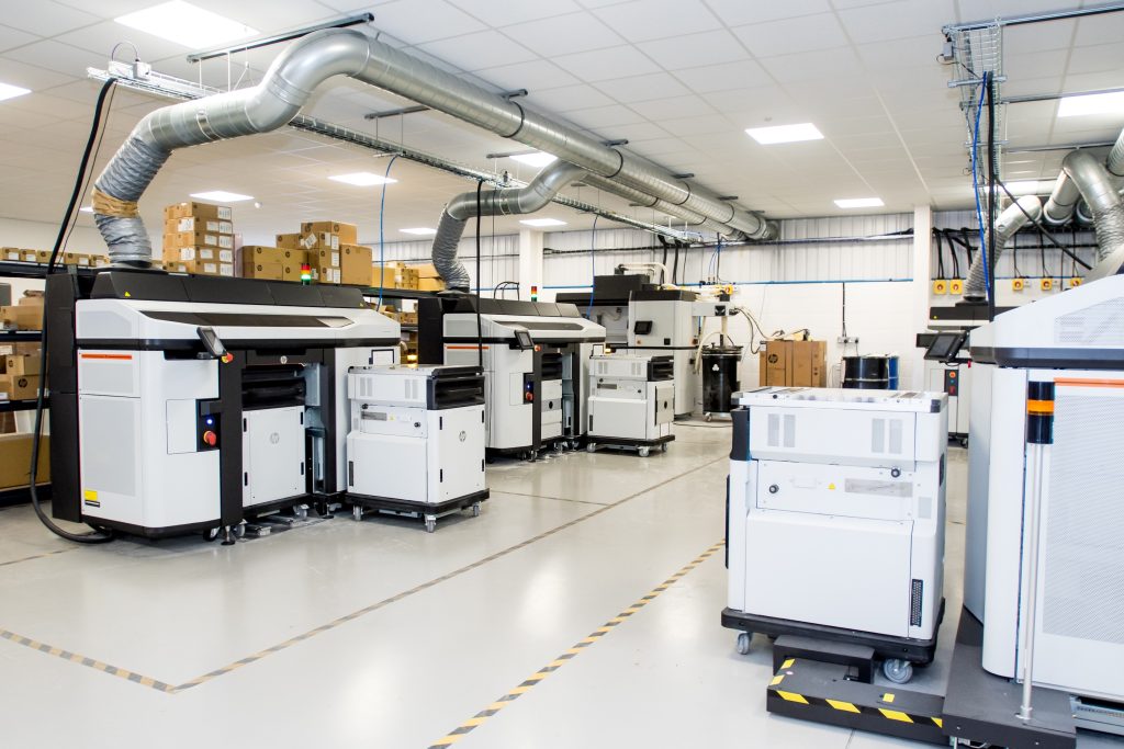 Factory floor showing multiple 3D printers.