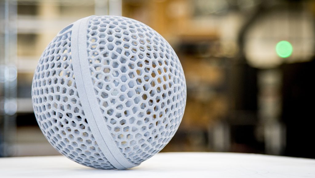 A grey 3D printed hollow sphere with a honeycomb lattice shell