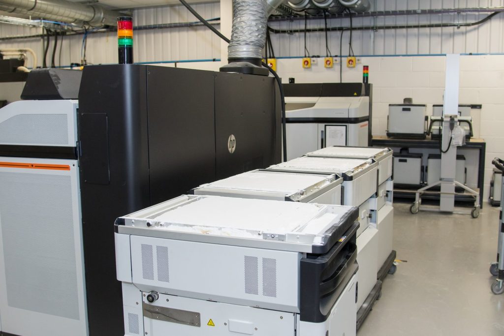 HP Multi Jet Fusion 3D printer with build units on the AMufacture production floor