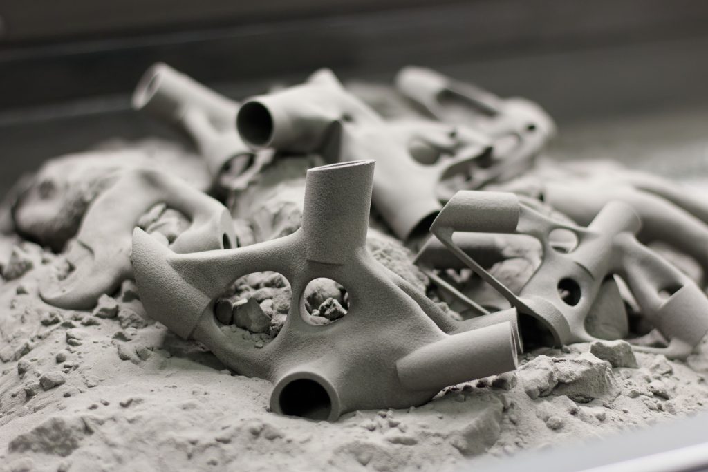 Freshly sintered SLS parts sitting in unfused nylon powder in the build chamber
