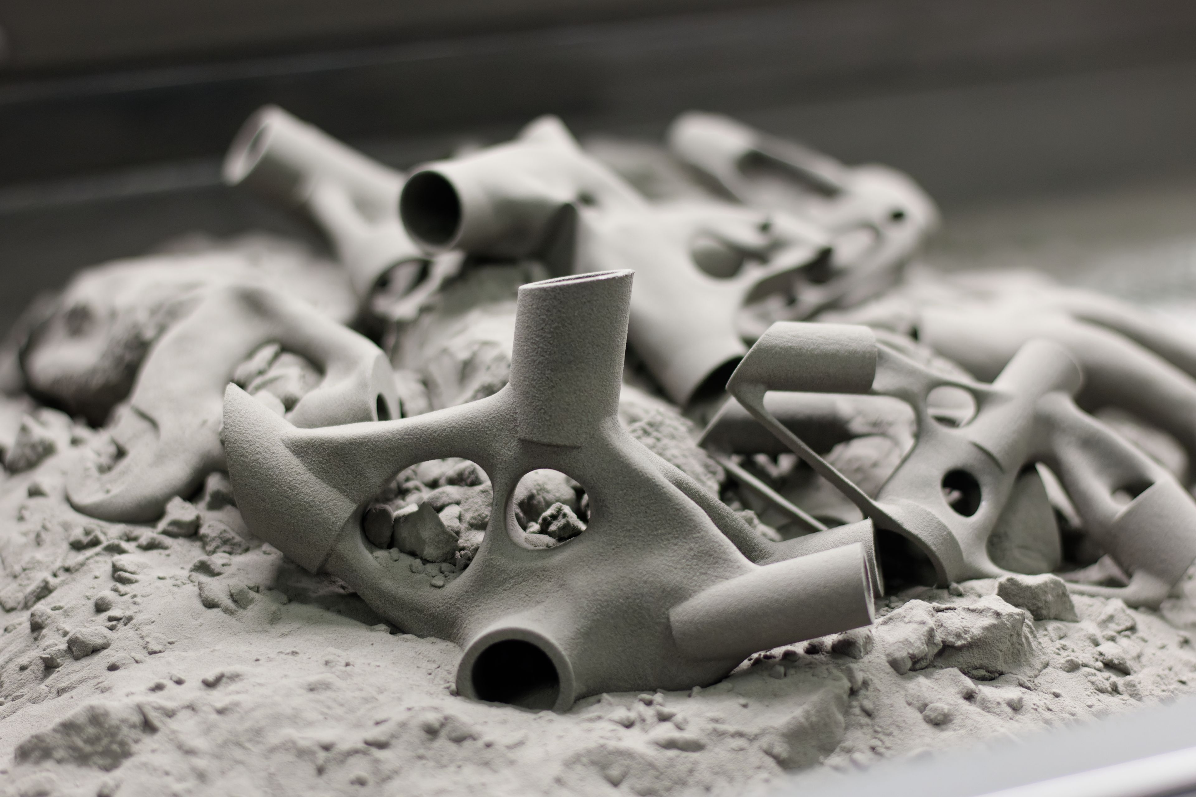 Freshly sintered SLS parts sitting in unfused nylon powder in the build chamber