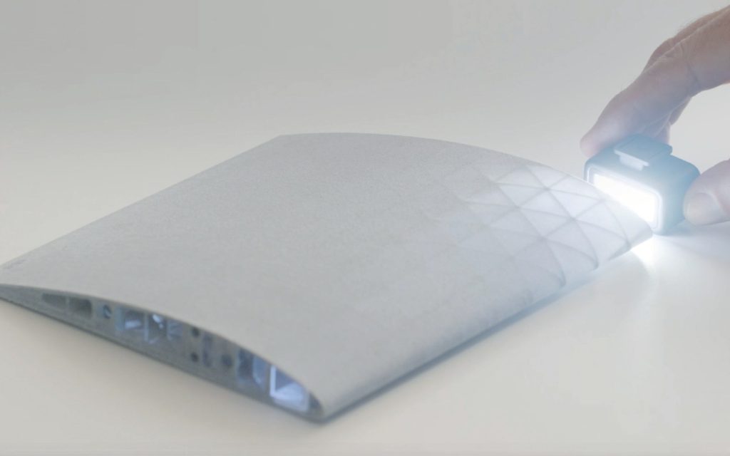 A 3D printed wing section backlit to reveal its internal lattice structure.